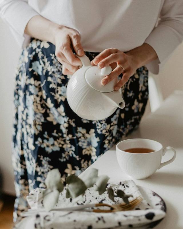 A caregiver pouring a cup of tea at home